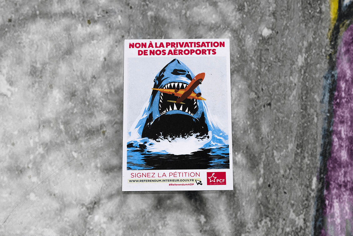 0552 : Sticker militant du PCF contre la privatisation d'ADP. Ici, on voit un détournement de l'affiche du film Jaws. Les stickers militants comportent souvent des dessins afin d'attirer l'oeil des passants. (19 décembre 2019)
