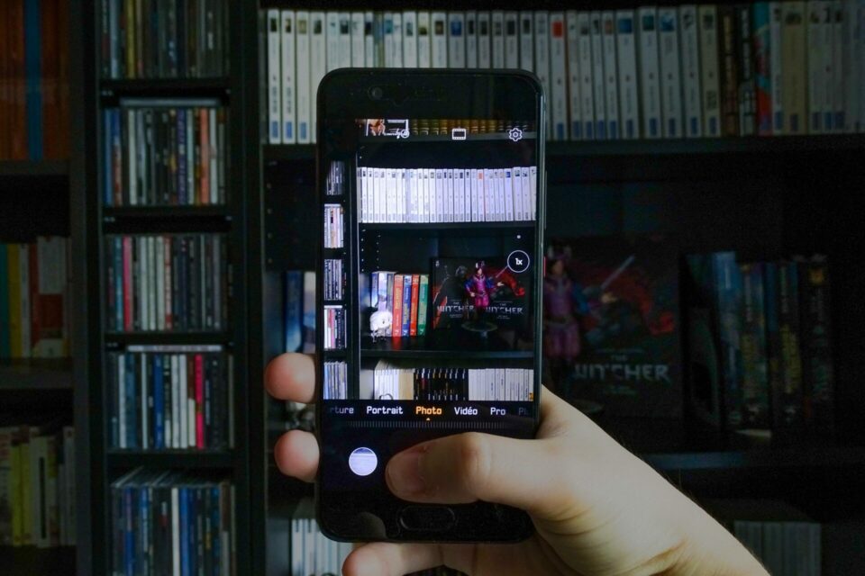 Téléphone prenant en photo une étagère remplie de livres