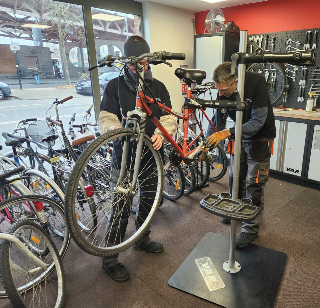 Réparation d'un vélo à Pass'O'Vert par des salariés de l'ALEFPA